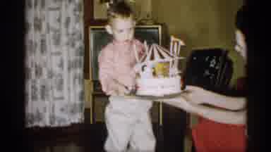 Michigan (1959): Child Being Ended Cake That Looks Like Carnival Ride S He Looks