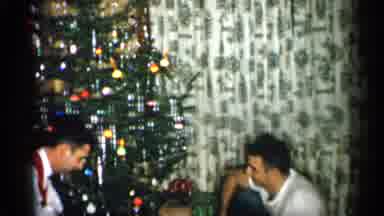 Michigan (1959): Child Things Small White Ornament On Lit Christmas Tree