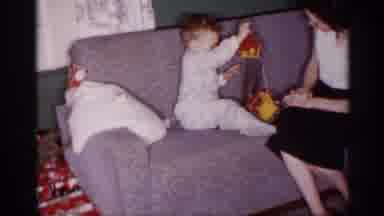 Michigan (1959): Woman Plays With Young Baby On Couch With Toy Toddler In Cot