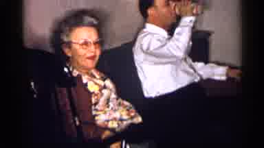 Michigan (1959): An Older Lady In Glasses Sitting Next To A Man In A Shirt And Tie