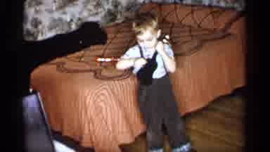 Michigan (1959): Indoor Recording Showing A Male Child Playing With A Small Guitar