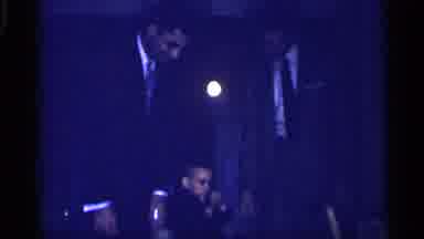 Michigan (1959): Small Boy Wearing Black Suit Walks Between Two Men Wearing Suits