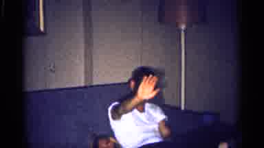 MICHIGAN-1959: Man On Couch Holding Baby, Smiling And Waving, Woman At Dinner Table