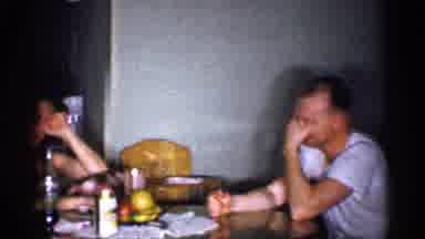 Michigan (1959): Three Adults Sit At Table Talking In Kitchen Area Of Home With