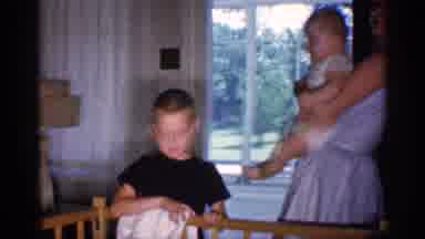 Michigan (1959): Woman Picking Up Baby From Crib And Sitting Child Waving