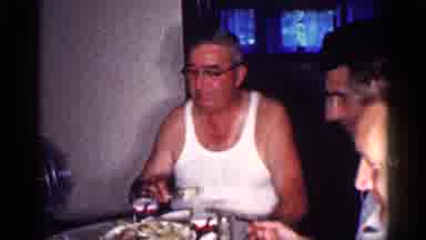 MICHIGAN-1959: A Man Enjoys Dinner With Family And Rests In A Green Armchair