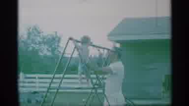 New York (1959): Man Wearing White Shirt Holds Child Wearing Blue Shorts Up To Top