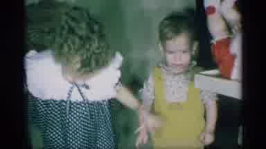 New York (1959): Child In Checkered Dress Smiles And Dances Indoors Next To