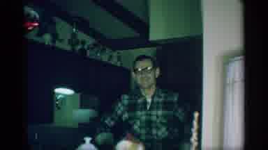 New York (1959): Woman Sitting In Chair Wearing Glasses Smiles And Waves At Camera