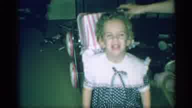 New York (1959): Laughing Toddler Girl In A Polka-Dot Dress With Toy Pink Striped