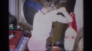 New York (1959): Child Pulls A Toy Out Of A Red Bag Hanging From A Door During
