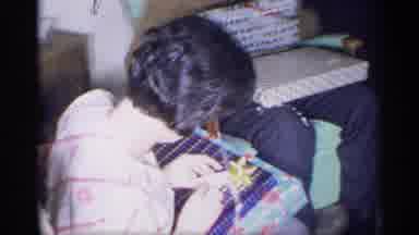 New York (1959): Boy Wearing Red Plaid Shirt Retrieves Red Gift Box From