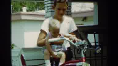 Mississippi (1963): Boy Holding A Baby Pretending To Be Riding The Bike And