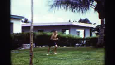 Mississippi (1963): Male Child Runs Across Lawn And Jumps Into Sprinkler In