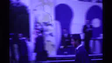 Ohio USA (1969): Man Walking Fast Wearing Blue Graduation Uniform With Hat Girl