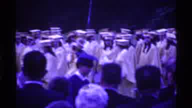 Ohio USA (1969): Graduating Students Wearing White Gowns March In Line On A Clear