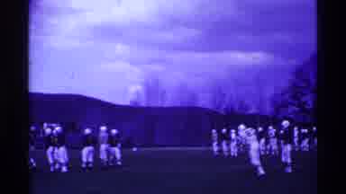 Ohio USA (1969): Football Player Wearing White Uniform Kicks Football On A Clear