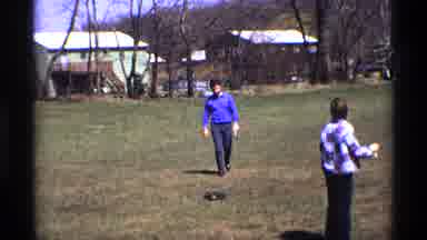 Florida Michigan (1970): Man Wearing Blue Shirt Walks Towards Kids Flying Kite On