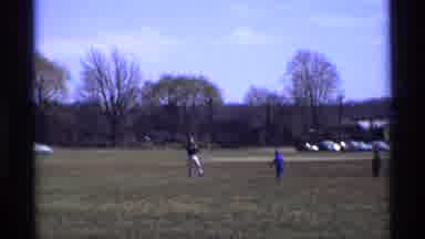 Florida Michigan (1970): Man Wearing White Pants Throws Object To Boy Wearing Blue