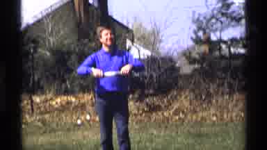 Florida Michigan (1970): A Man In A Blue Shirt Stands In A Yard And Rolls String