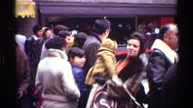 New York City (1970): Mother Holds Infant In Arms In Crowded Location Before