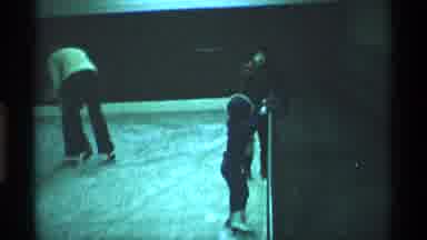New York City (1970): Child Wearing Blue Coat Clings To Wall Of Ice Skating Rink