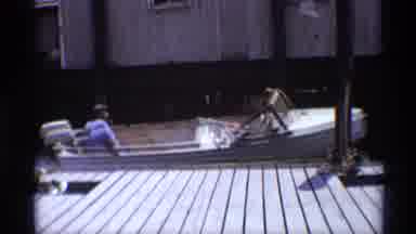 New York (1973): A Man In A Blue Shirt Steers His Small Weathered White Boat Away