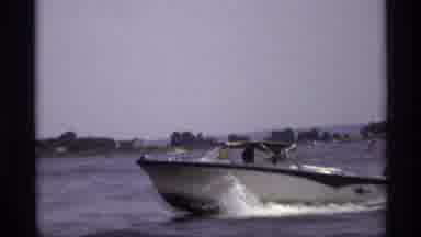 New York (1973): A Nice Blue And White Boat Driving Quickly Across A Lake