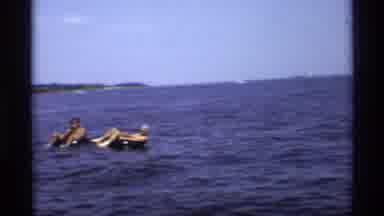 New York (1973): People In Water Tubes On A Lake Waving As Cameraman Passes