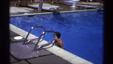 New York (1973): Child Climbs Out Of Pool Using A Ladder While Another Child Uses