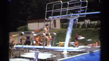 New York (1973): Two Boys Wearing Black Shorts Dive Into Swimming Pool On A Bright