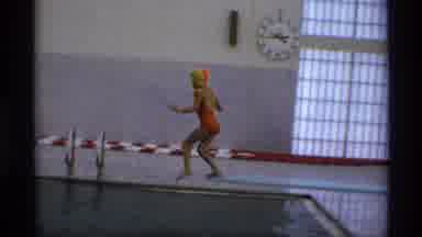 New York (1973): Person Wearing Orange Swimwear Jumps Into Pool From Diving Board