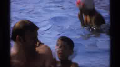 New York (1973): Mother Coaxes Small Male Child To Swim To Her In Pool