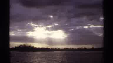 Orlando Florida (1974): Sun Shining Thru Clouds Onto Trees And Water