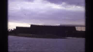 Orlando Florida (1974): Zooming In On Large Brown Building Across Water With Trees