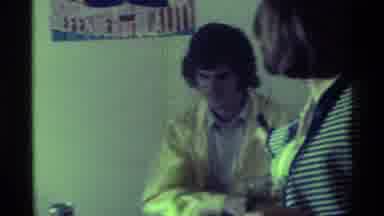 Kentucky (1976): Off Screen Person Holds Black Microphone To Man Wearing Yellow