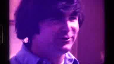 Kentucky (1976): Man Wearing Blue Shirt Looks Around While Talking Directly To