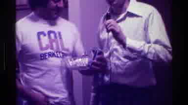 Kentucky (1976): Two Men At A Party Communicating With One Another And Film Taker