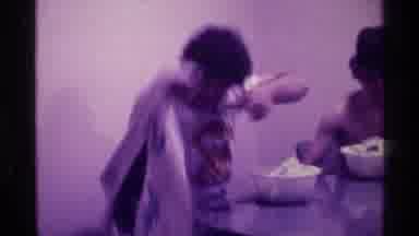 Kentucky (1976): Two Adult Males Sit At Table Acting Silly In Front Of Camera