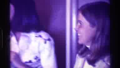 Kentucky (1976): Woman Wearing White Shirt Talks Into A Small Black Microphone