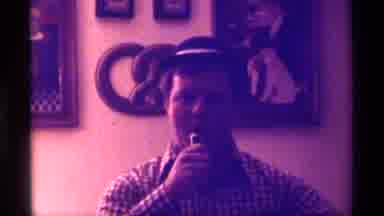 Kentucky (1976): Man Wearing Small Black Hat Hands Microphone To Off Screen Person