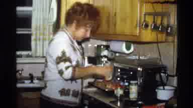 California (1978): A Woman Is Cooking In A Kitchen Adding A Spice To A Dish