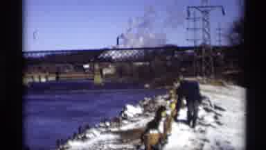 Madison Wisconsin (1966): Person Wearing Black Coat Walks Along Snow Covered River