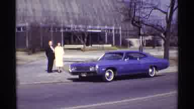 CHICAGO ILLINOIS-1968: Couple In Formal Wear With Purple Muscle Car Outside Conservatory