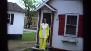 Holland Michigan (1969): Woman In Bright Outfit Poses In Front Of House For