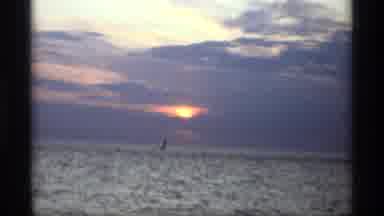 Holland Michigan (1969): The Sun Setting Over The Ocean And Buildings In A Small