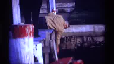Holland Michigan (1969): Man Reaching From Dock Cuts To Boat In Sunset