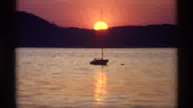 Holland Michigan (1969): View Of Single Sailboat In Water With Gold Sunset Behind