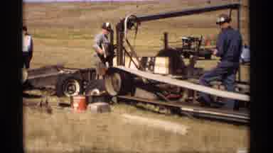 Jordan Minnesota (1969): Two Men Use A Big Band Saw Machine To Cut A Wooden Slat