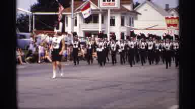Mabel Minnesota (1969): Band Members Wearing Black Uniforms March Down Street On A